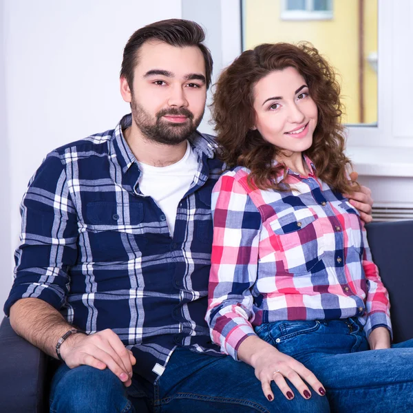 Šťastný pár sedí na pohovce v obývacím pokoji — ストック写真