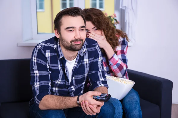 Pasangan muda dengan popcorn menonton film menakutkan di tv — Stok Foto