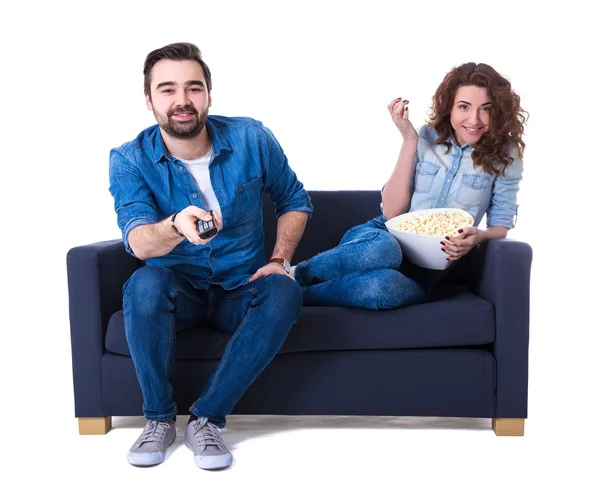 Giovane uomo felice e donna che si siede sul sofà con popcorn e guardare — Foto Stock