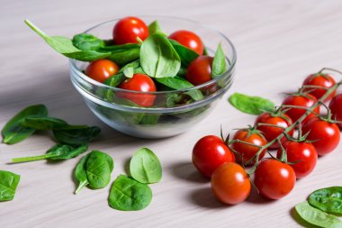 Ispanak ve ahşap masa üzerinde domates salatası, yakın çekim