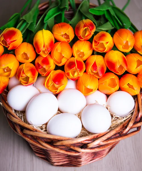 Koncepcja Wielkanoc - bliska białych jaj i tulipany w koszyku — Zdjęcie stockowe