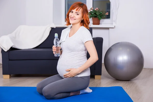 Mulher grávida feliz relaxante após o treino de fitness em casa — Fotografia de Stock