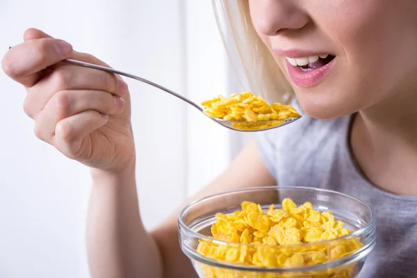 Retrato de jovem tomando café da manhã com flocos de milho — Fotografia de Stock