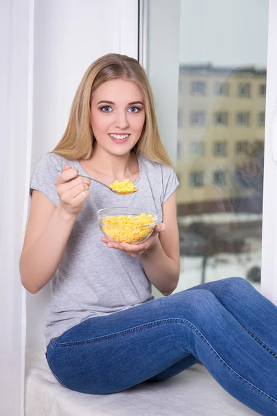 Mujer comiendo hojuelas de maíz en casa — Foto de Stock