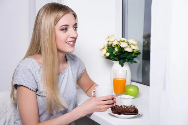 Retrato de jovem sorridente tomando café na cozinha — Fotografia de Stock