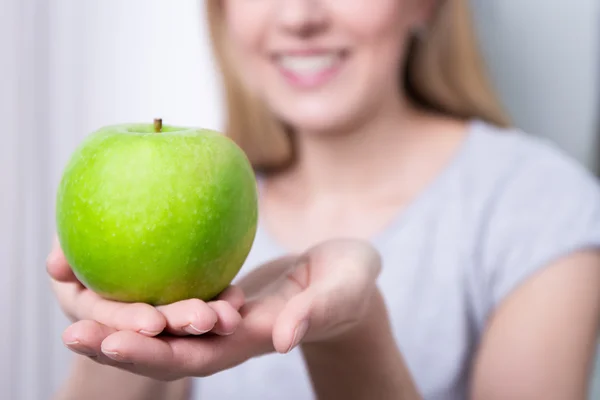 Cerca de manzana verde en manos femeninas — Foto de Stock