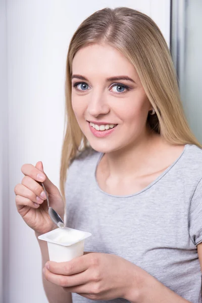 Concetto della prima colazione - giovane donna che mangia yogurt — Foto Stock