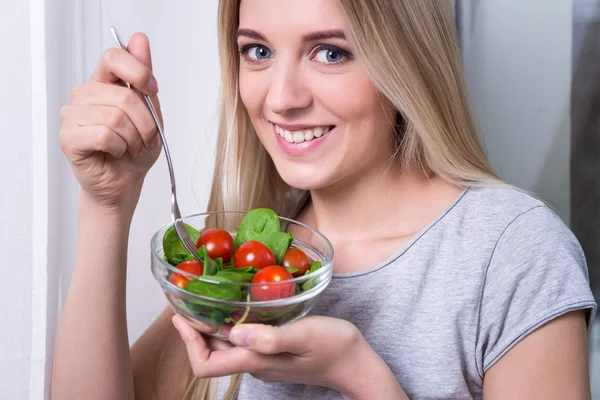 Cerrar retrato de mujer joven comer ensalada con tomates y —  Fotos de Stock