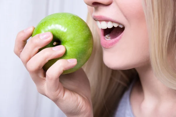 Närbild porträtt av kvinnan bita grönt äpple — Stockfoto