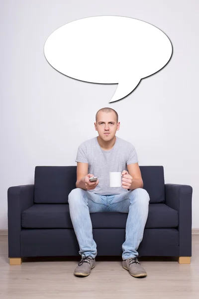 Young man sitting on sofa and dreaming about something — Stock Photo, Image