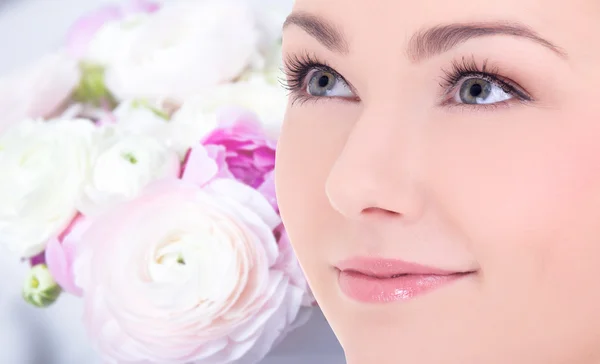 Close-up van portret van mooie vrouw over bloemen achtergrond — Stockfoto