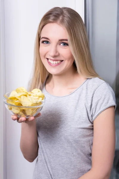 Happy young woman holding bowl with chips — Stock Photo, Image