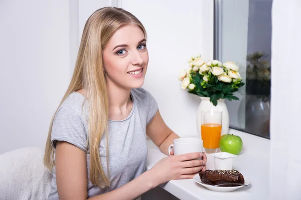 Retrato de mujer joven desayunando en la cocina — Foto de Stock