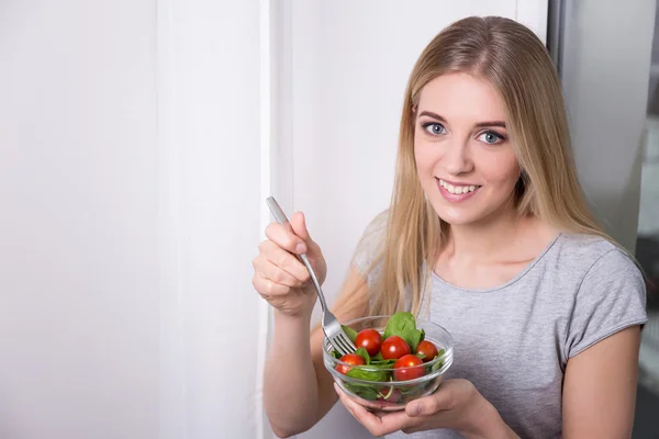 Retrato de mujer joven comer ensalada con tomates y espinacas — Foto de Stock