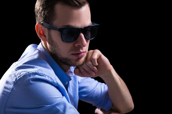 Young sad man in sunglasses thinking about something over black — Stock Photo, Image