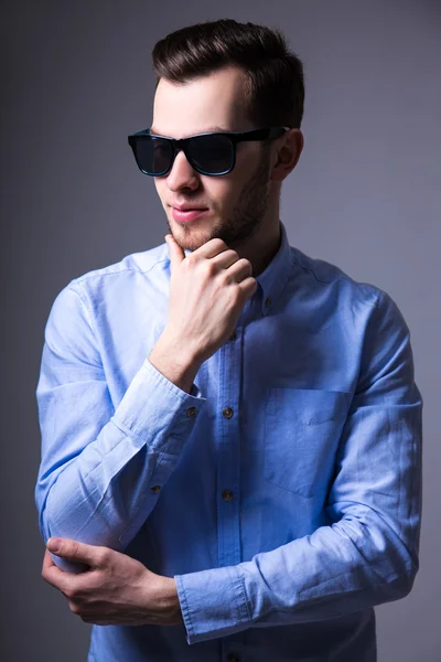 Young handsome man in sunglasses thinking about something over g — Stock Photo, Image