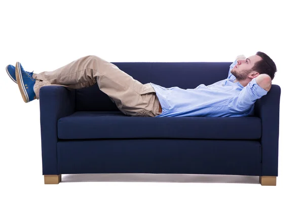 Schöner Mann auf Sofa isoliert auf weiss liegend — Stockfoto