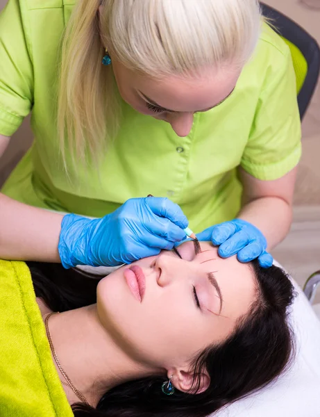 Kosmetolog förbereder unga kvinnan för permanenta ögonbryn gör upp p — Stockfoto
