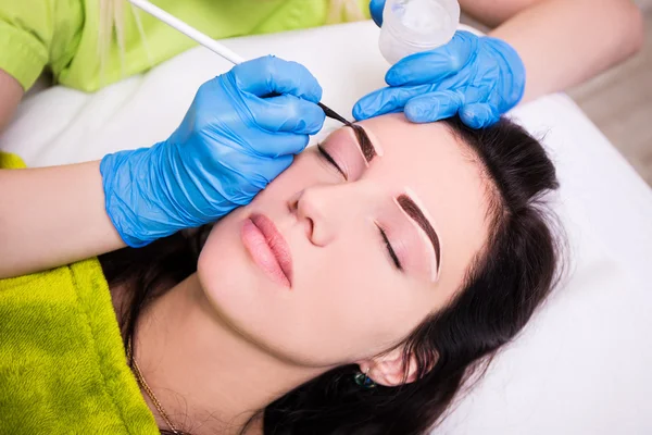 Permanent eyebrow make up - beautician applying anesthesia and p — Stock Photo, Image