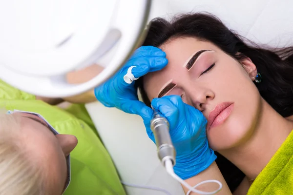 Top view of cosmetologist applying permanent make up on eyebrows — Stock Photo, Image