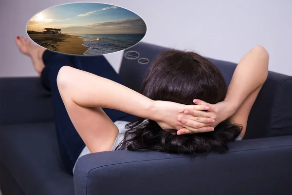 Back view of woman lying on sofa and dreaming about summer vacat — Stock Photo, Image