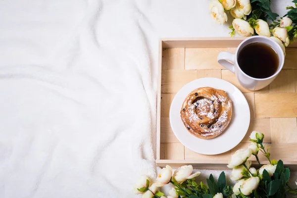 Good morning - breakfast with bun and tea on wooden tray and flo — Stock Photo, Image