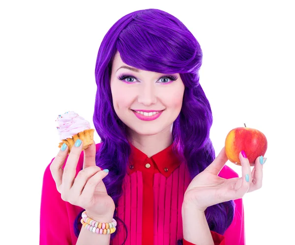 Lächelnde Frau mit lila Haaren hält Apple und Cupcake isolieren — Stockfoto