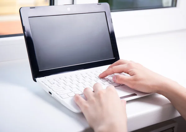 Mulher usando laptop com tela em branco — Fotografia de Stock