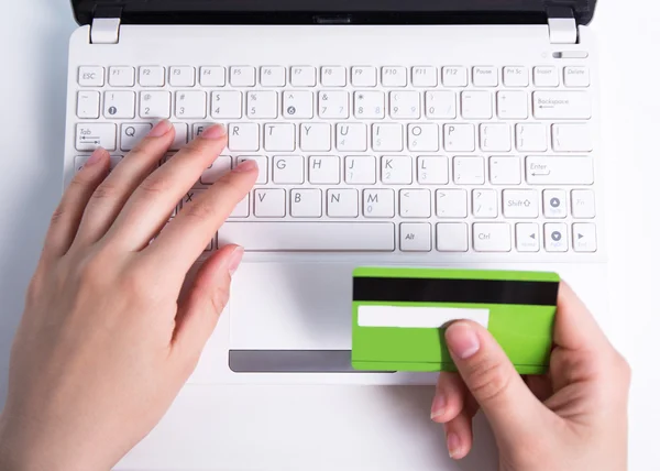 Compras online - las manos femeninas con tarjeta de crédito y portátil —  Fotos de Stock