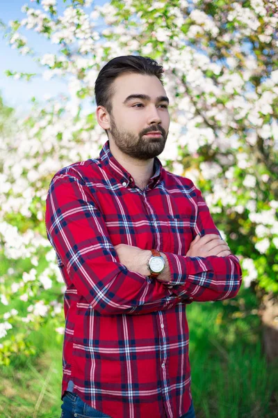 Agriculteur de jeune bel homme dans jardin fleuri — Photo