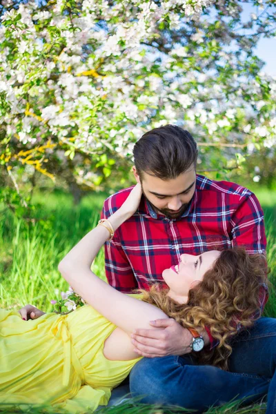 Junger Mann mit seiner Freundin im Park sitzen — Stockfoto