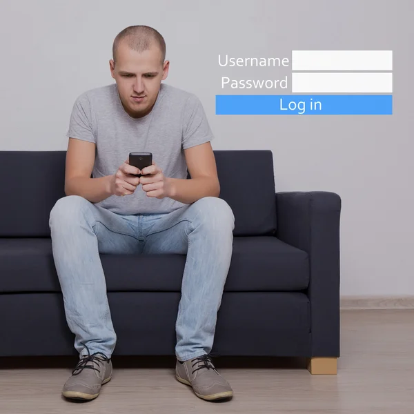 Nom d’utilisateur et mot de passe - bel homme assis sur le canapé avec téléphone portable — Photo