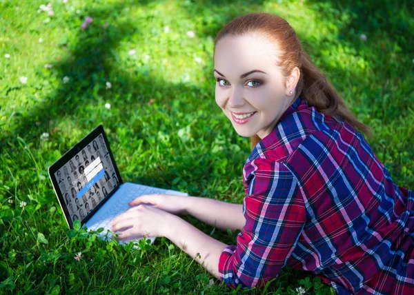 Internet access concept - happy teenage girl lying with laptop o — Stock Photo, Image