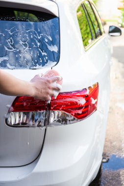 adam arka ışıklar bir sünger ile araba yıkama