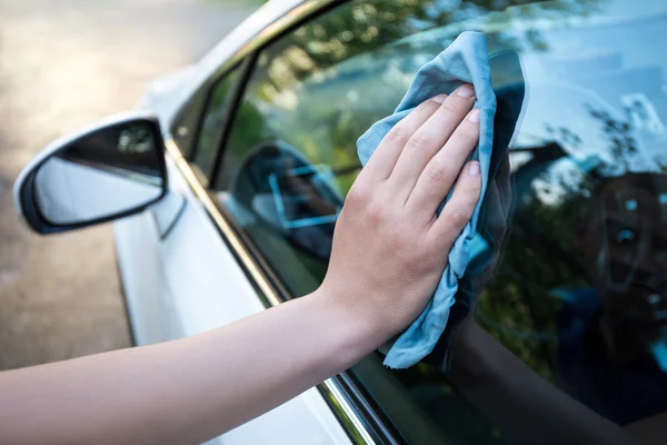 male hand cleaning car window with microfiber cloth