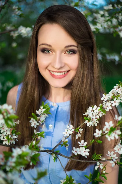 Leende kvinna i blommande cherry garden — Stockfoto