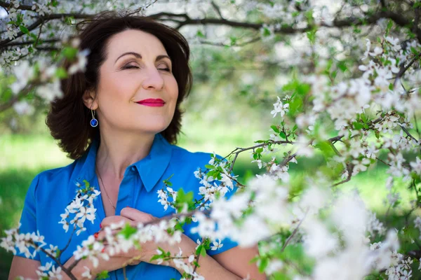 Close up portrait of middle aged woman in cherry garden — Stock Photo, Image