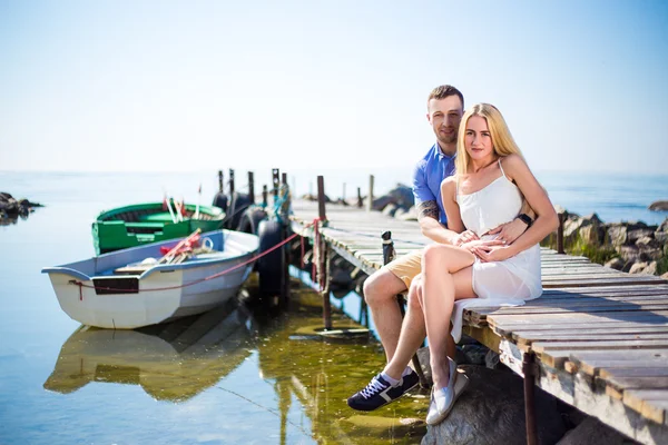Romantik genç güzel çift iskelede oturup portresi — Stok fotoğraf