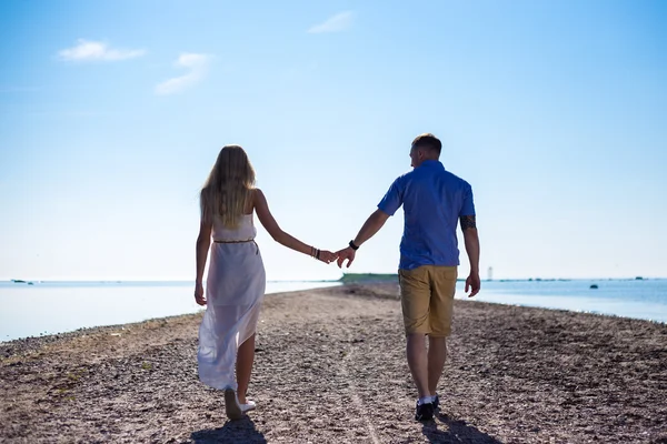 Vackra par i kärlek promenerar på stranden — Stockfoto
