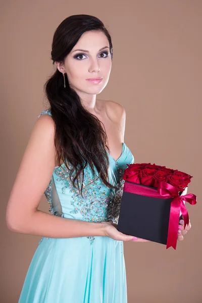 Retrato de mulher bonita, segurando a caixa com flores rosas vermelhas — Fotografia de Stock