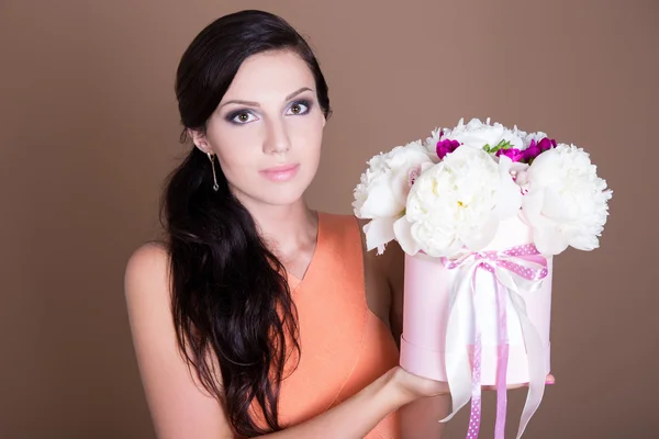 Linda mulher segurando a caixa com flores de peônia — Fotografia de Stock