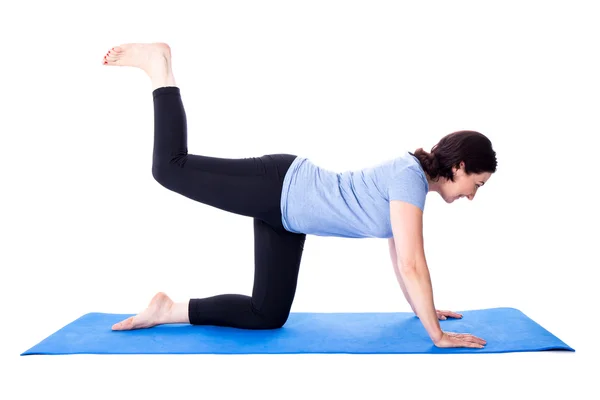 Mujer madura delgada haciendo ejercicios en estera de yoga aislado en blanco —  Fotos de Stock