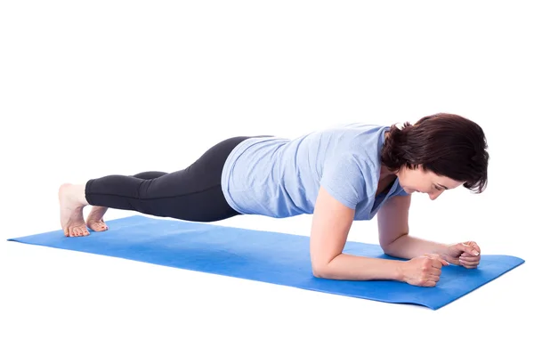 Mogen kvinna gör övningar på yogamattan isolerad på vit — Stockfoto