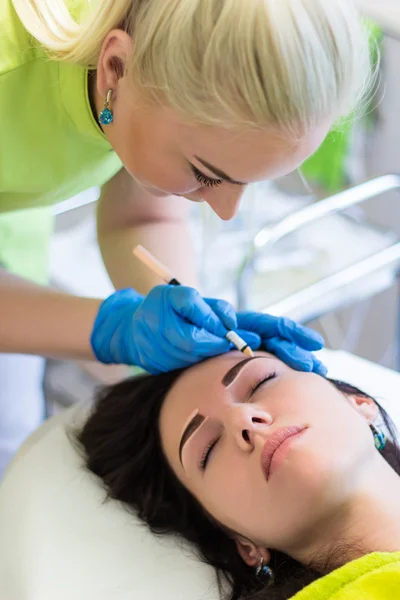 Professional cosmetologist preparing young woman for permanent e — Stock Photo, Image