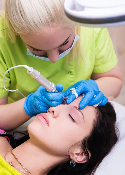 Professional cosmetologist applying permanent make up on eyebrow — Stock Photo, Image