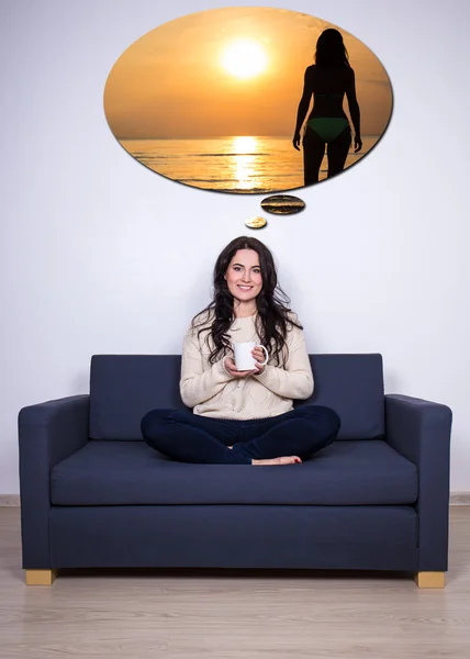 Resa koncept - ung kvinna sitter på soffan med kopp te och — Stockfoto