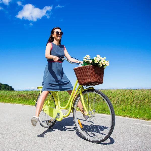 Glücklich lustige junge Frau reitet auf dem Fahrrad mit angehobenen Beinen — Stockfoto