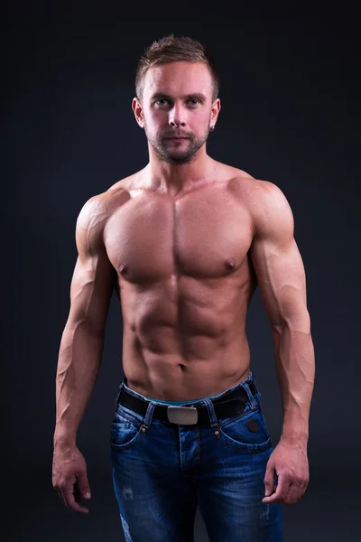 暗い背景の上に立って若い筋肉男の肖像 — ストック写真
