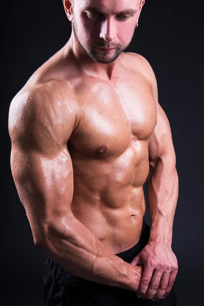 Porträtt av sexiga unga muskulös man står över grå — Stockfoto