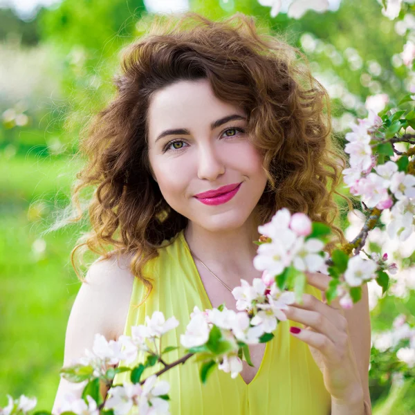 Portret van jonge mooie vrouw met bloeiende boom — Stockfoto